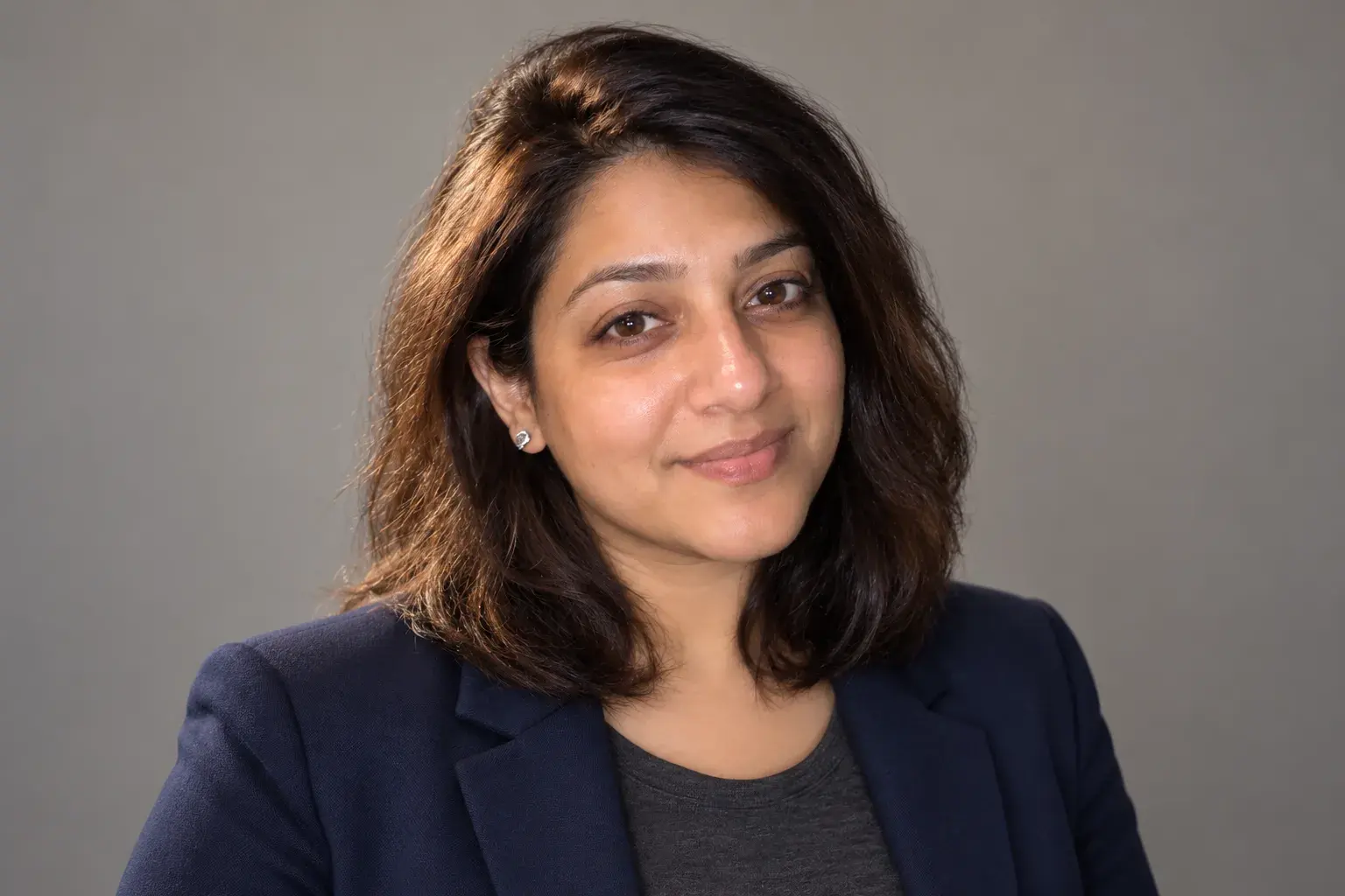 Woman in a navy blazer, a clean, well lit work headshot