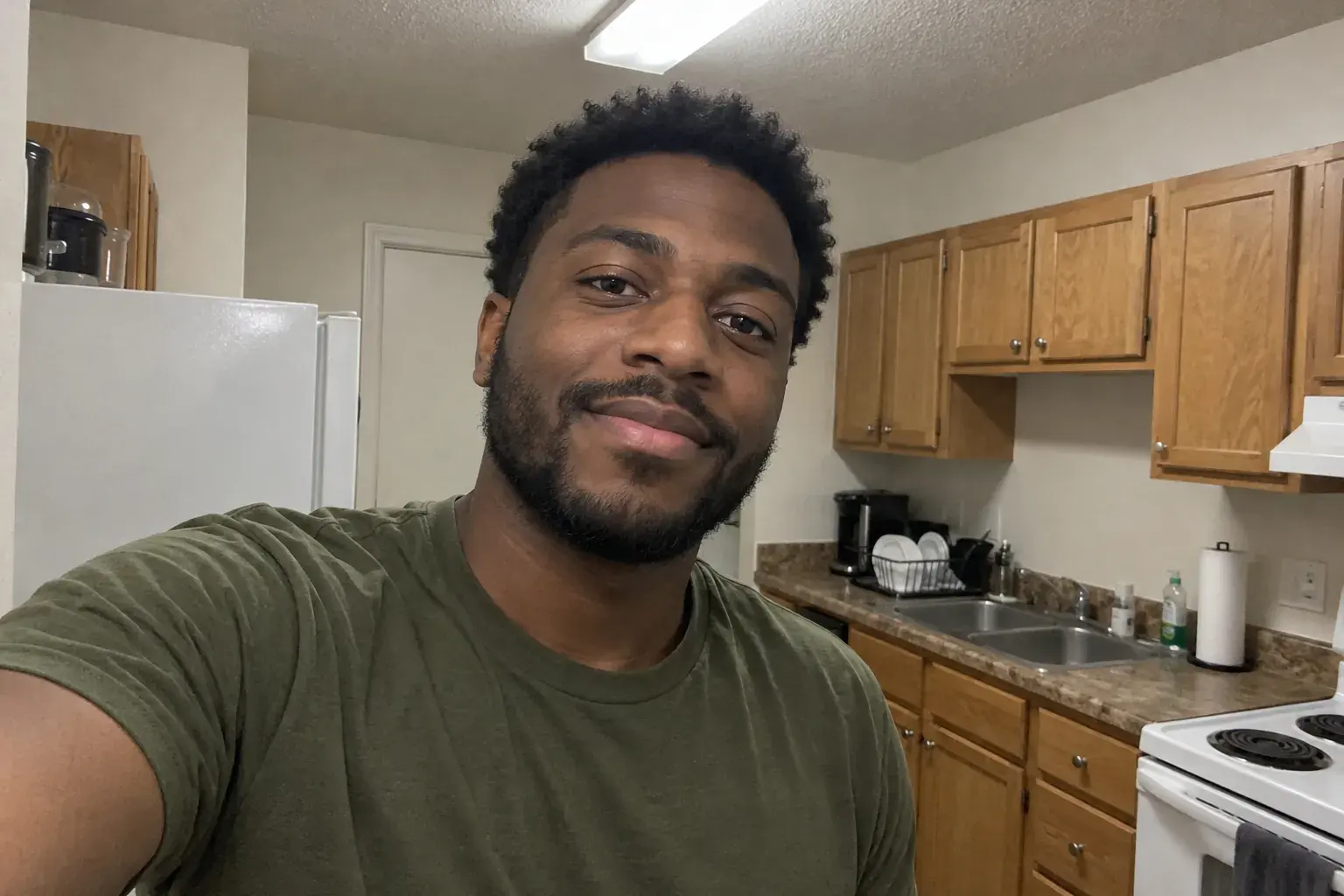 Selfie of a man in a kitchen under flat indoor light