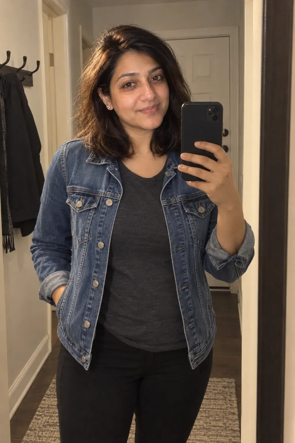 Mirror selfie of the same woman in a denim jacket